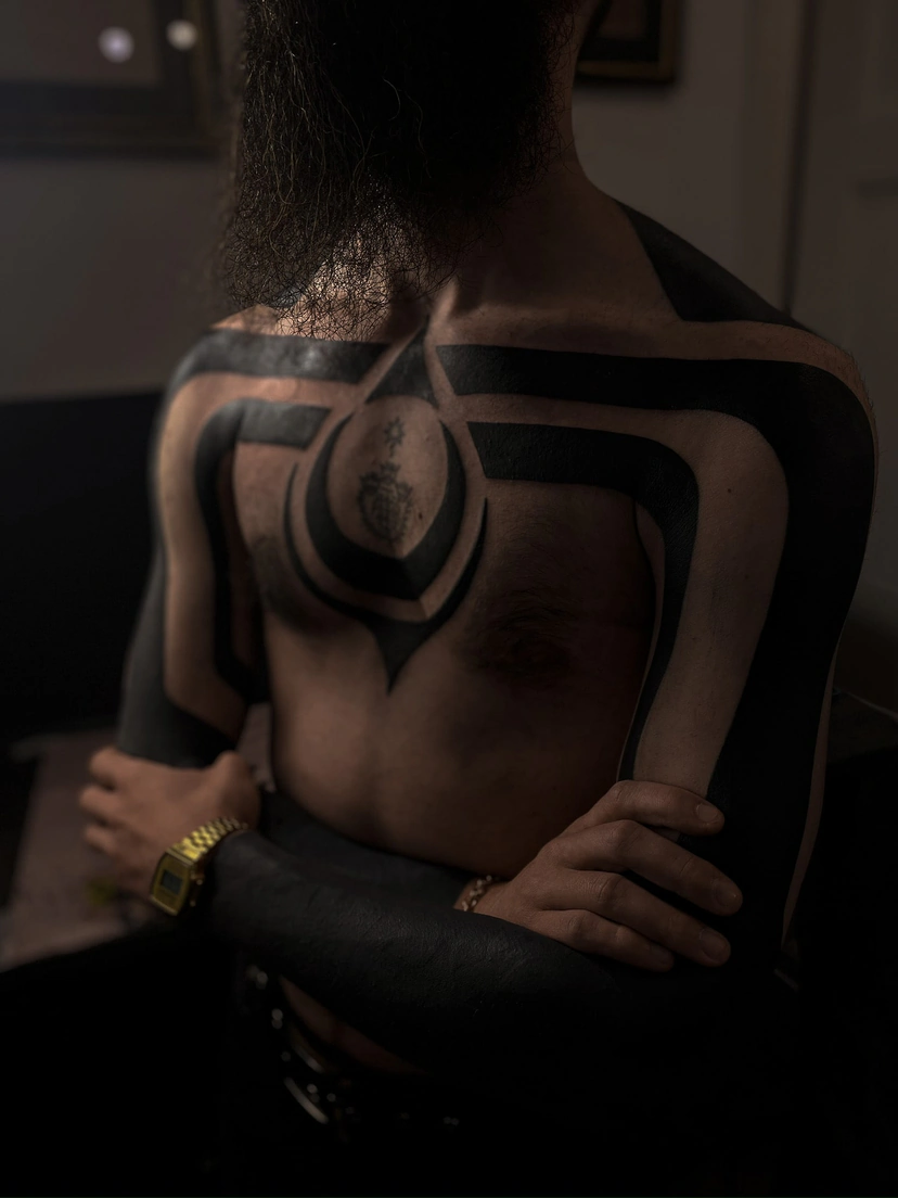 Czarny tatuaż blackwork na rękach i klatce piersiowej