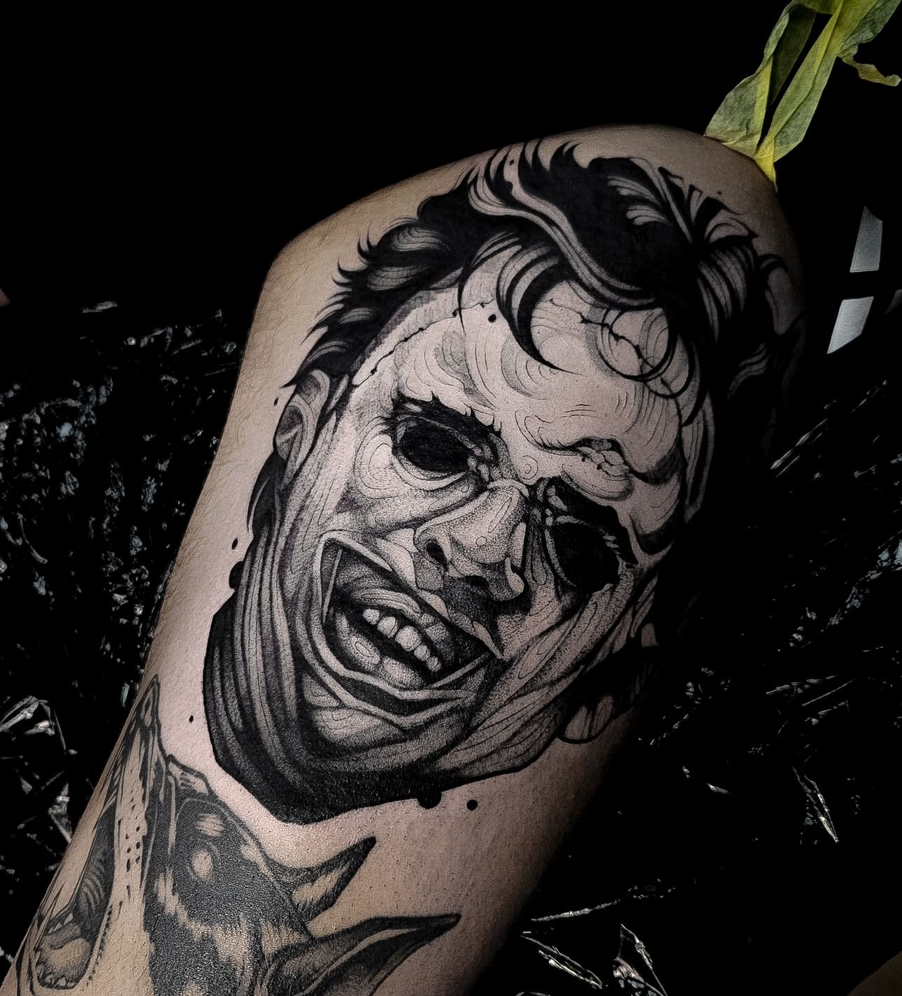 Na zdjęciu czarny tatuaż blackwork, horror, graficzny wykonany na udzie przedstawiający postać leatherface, wykonany w studio tatuażu Uroki w Warszawie