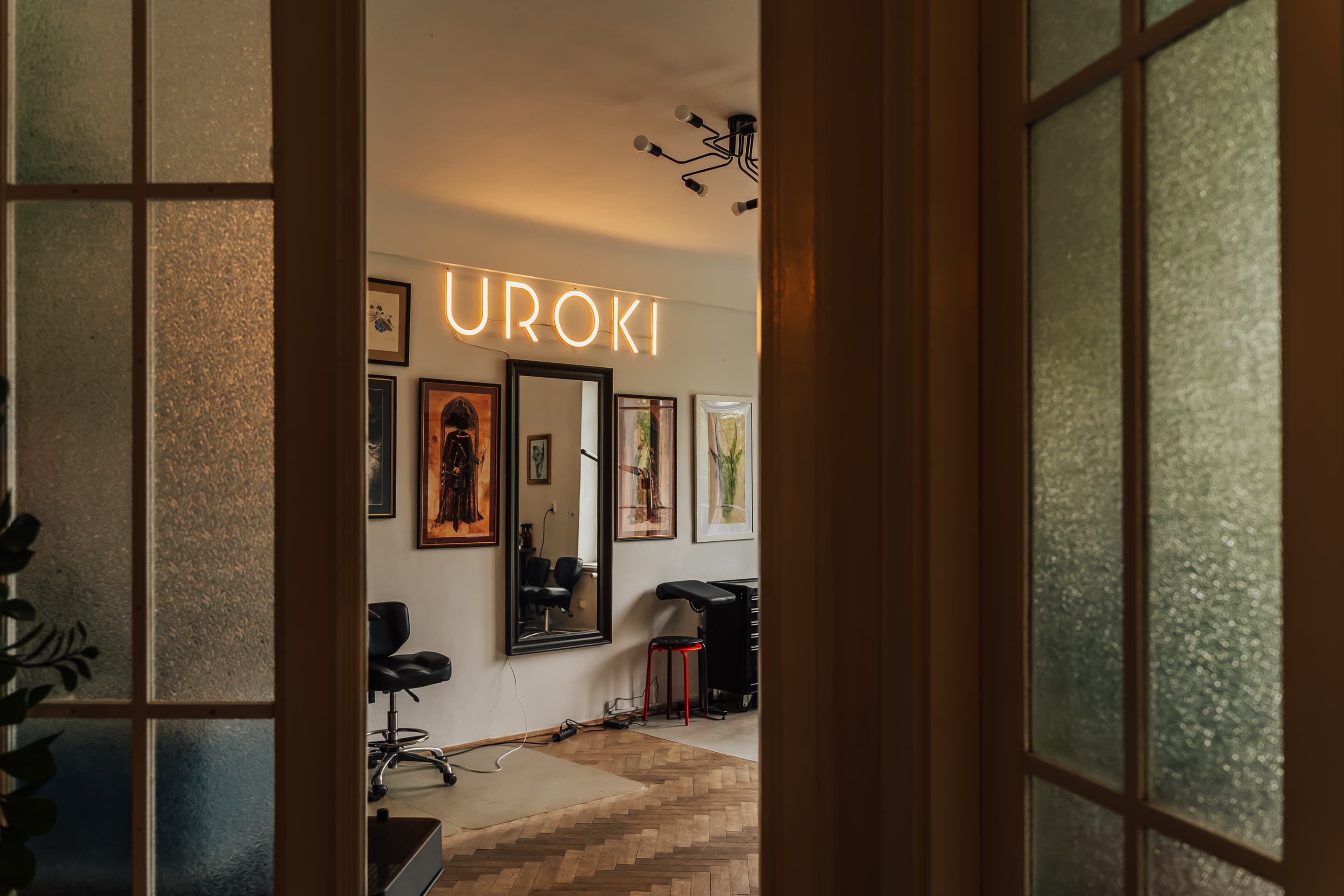 Wnętrze studia z logiem studia tatuażu uroki oraz obrazy różnych artystów
